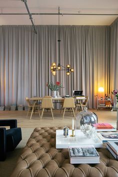 a living room filled with furniture next to a tall glass vase on top of a coffee table