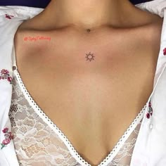 a woman with a small sun tattoo on her upper back shoulder and chest, wearing a white shirt