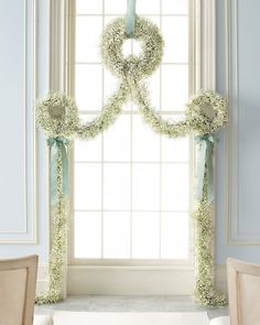 two wreaths on the window sill with ribbons around them