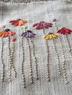 a close up of a piece of cloth with flowers on it and thread in the middle