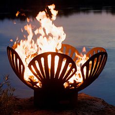 a large fire pit sitting on top of a lake next to a body of water