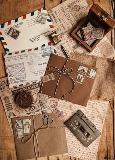 an assortment of old fashioned envelopes and stamps on a wooden table with a wax stamp