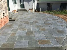 an outdoor patio with stone steps leading up to the front door and side of a house