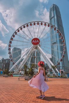 a woman standing in front of a ferris wheel