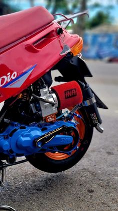 a red and blue motorcycle parked on the street