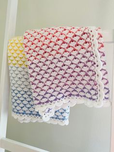 three crocheted dishcloths hanging on a ladder