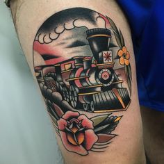 a man with a train tattoo on his arm and leg, next to a flower