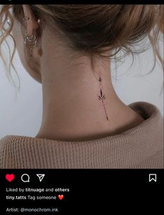 a woman's neck with a small flower tattoo on the back of her neck