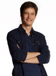 a young man with his arms crossed smiling