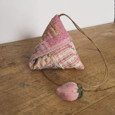 a small pink object sitting on top of a wooden table next to a piece of cloth