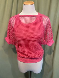 This is a fun vintage top from the 70s or 80s.  Labeled has been snipped out. The bust measures 25" to 34", see measurements below. This fun top has the look of 2 layered tops but is all in one. It is a pink cotton blend strappy, sleeveless tank top bottom layer with a mesh short sleeve top layer. The two layers are attached at the band bottom. The tank part is a soft ribbed tank. The mesh is an open weave with dolman sleeves. The sleeves have knit cuff bands, as does the neckline.    The top is in very good condition!  No damage or soil. Super cute!  If you have never worn vintage before, please measure yourself!! Vintage sizes run smaller than today's sizes, know your measurements before buying! Bust measured from side seam to side seam at the underarm: stretches from 12.5" to 17" for a Spring Vintage Crew Neck Crop Top, Vintage Crew Neck Crop Top For Spring, Vintage Stretch Short Sleeve Tops, Retro Short Sleeve Crop Top For Spring, Retro Crew Neck Top For Spring, Vintage Pink Summer Tops, Vintage Pink Tops For Summer, Vintage Pink Top For Summer, Pink Retro Stretch Top