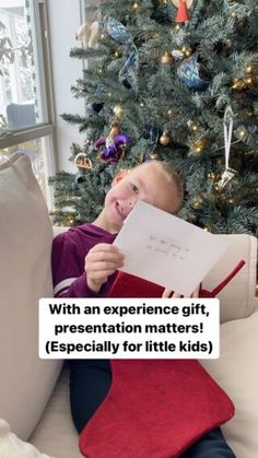 a little boy sitting on a couch reading a book next to a christmas tree with the words, with an experience gift, presentation matters especially for little kids