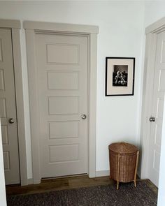 a room with two doors and a basket on the floor