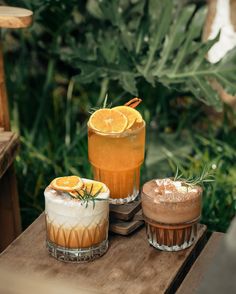 three drinks sitting on top of a wooden table