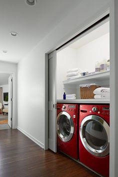 a washer and dryer in a room with wood flooring on the other side