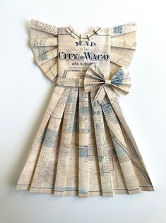 a dress made out of old newspapers with a bow on the front and back side