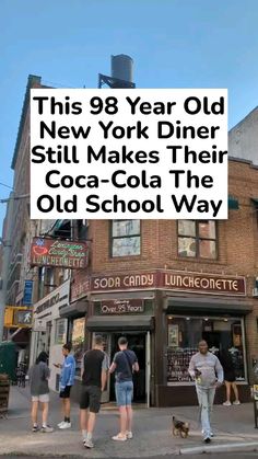 people are walking on the sidewalk in front of an old school restaurant with a sign that reads, this 98 year old new york diner still makes their coca - cola