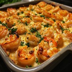 a casserole dish with shrimp and parsley on top, ready to be eaten