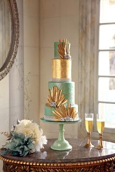 a three tiered cake sitting on top of a table next to a glass of wine