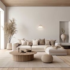 a living room with white furniture and wood flooring on the walls, along with a round coffee table