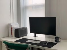 a computer monitor sitting on top of a white desk next to a keyboard and mouse