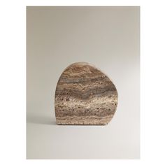 a rock shaped like a triangle with brown and white streaks on it's surface