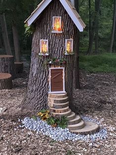 a tree house built into the side of a tree trunk with stairs leading up to it