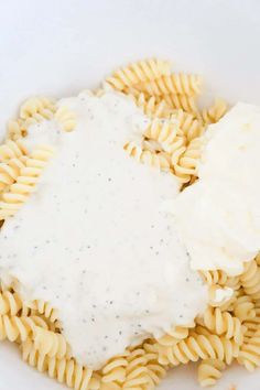 a white plate topped with pasta covered in cream sauce and cheese on top of it