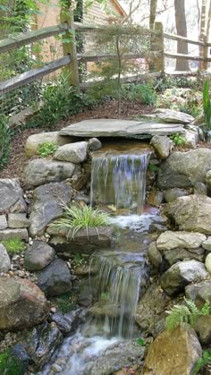 there is a small waterfall in the middle of this garden