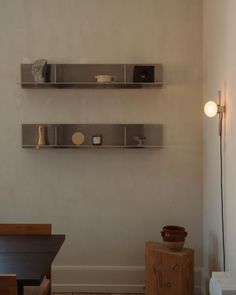 two shelves on the wall above a table