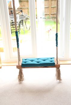 a blue cushioned swing in front of a sliding glass door