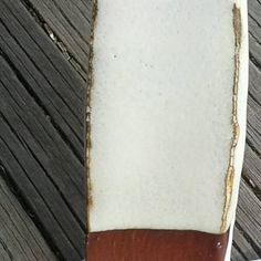 an old surfboard sitting on top of a wooden dock next to the ocean water