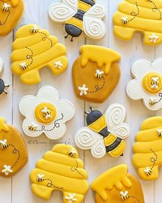 decorated cookies are arranged in the shape of bee's and honeybees on a white table