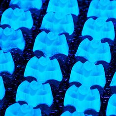 rows of blue plastic chairs sitting on top of a black table covered in water droplets