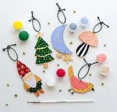 christmas ornaments are laid out on a white surface with a pencil in the foreground