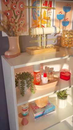 a shelf filled with lots of different items on top of a white table next to a vase