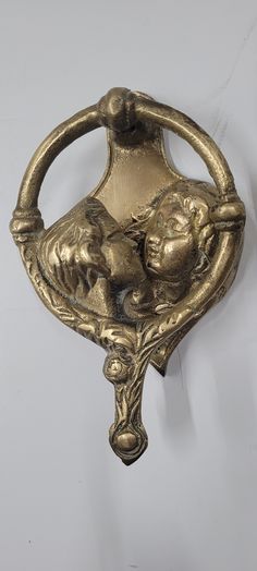 an ornate brass door handle on a white wall