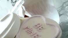 two heart shaped cookies sitting on top of each other next to some paper wrappers