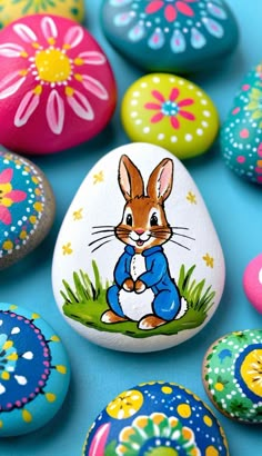 colorful painted rocks with an image of a rabbit on one and flowers on the other