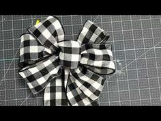 a black and white checkered bow sitting on top of a piece of paper next to scissors