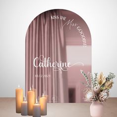 a vase filled with candles sitting next to a pink wall mounted sign that says, kiss the miss goodbye