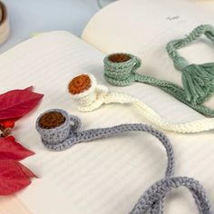 an open book with crocheted items on top of it and a poinsetti