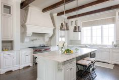 a large kitchen with white cabinets and an island