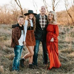 a family poses for a photo in an open field