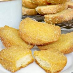 some fried food on a white plate next to a cup