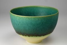 a green and yellow bowl sitting on top of a table