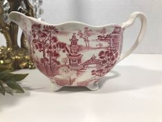 a red and white china tea cup sitting on a table