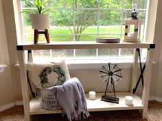 a window sill with a windmill, pillow and other items on it in front of the window