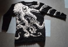 an octopus sweater is laying on the floor