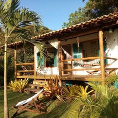 a small house with hammocks on the porch